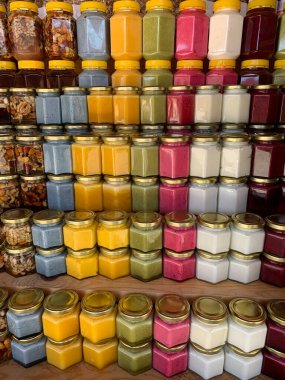 Tezgahta satılık bir sürü organik bal kavanozu var. Farklı bal, farklı renkte plastik kutular bal fuarında satılmaya hazır. Balla dolu fındık. 