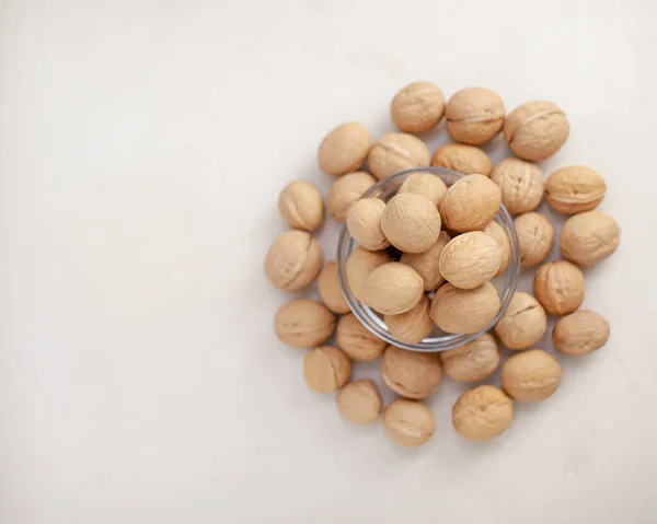 A lot of whole walnuts in a cup on a white background close-up. Healthy, organic food with a high content of protein and protein.