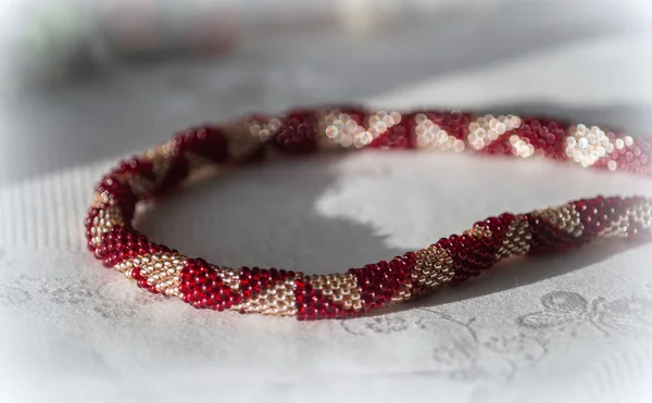 Crocheted beaded necklace of red and golden color