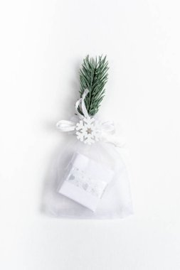 Xmas şenlik arka planı çok az. Noel 'de moda küçük DIY hediye paketi ve yeniden kullanılabilir dekorasyonlar - köknar dalı ve beyaz arka planda kar tanesi. Sürdürülebilir Noel. Üst Manzara. Dikey yönelim.