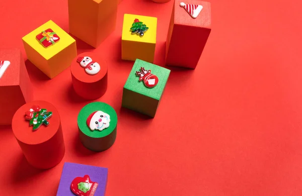 Närbild mjuka leksaker flerfärgade barn kuber av olika storlekar med jul symboler ovan på rött med kopia utrymme. — Stockfoto
