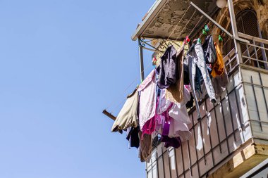 Kudüs 'ün eski bir şehrinde eski bir balkondaki iplerle çok renkli çamaşırlar kurutulur.