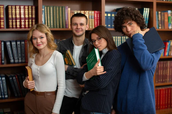 Um grupo de graduados universitários olhando para a câmera na biblioteca — Fotografia de Stock