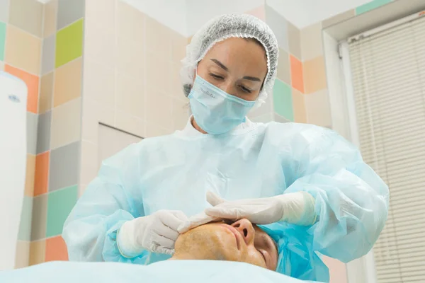 Kadın doktor mesolitler ve iplikler yapar hastayı erkeğe kaldırır