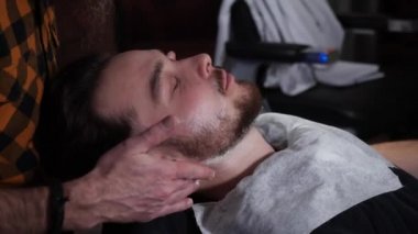 Traş olmadan önce bir müşteriye tıraş kremi sürerken yakın plan. 