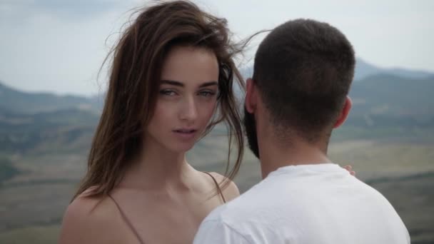 Vacker ung flicka kramar pojkvän och tittar in i kameran — Stockvideo