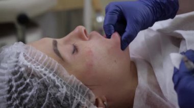Kozmetik kliniğindeki genç bir kadına elle masaj..