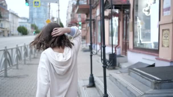 Belle fille tourbillonne sur le remblai marchant le long de la clôture — Video