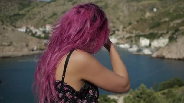 Молодая девушка с фиолетовыми волосами на фоне залива — стоковое видео