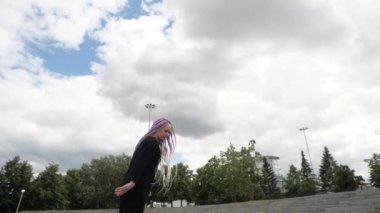 İlginç renkli at kuyruklu genç bir kadın paten üzerinde numaralar yapıyor.