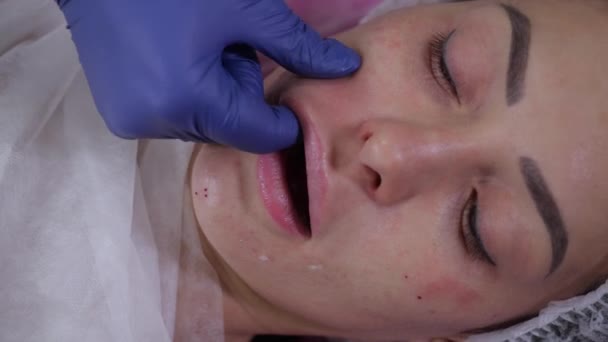 Egy kék orvosi kesztyűs kozmetikus masszírozza egy lány betegét. — Stock videók