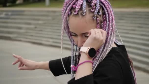 Helles junges Mädchen mit lila langen Zöpfen auf Rollschuhen — Stockvideo