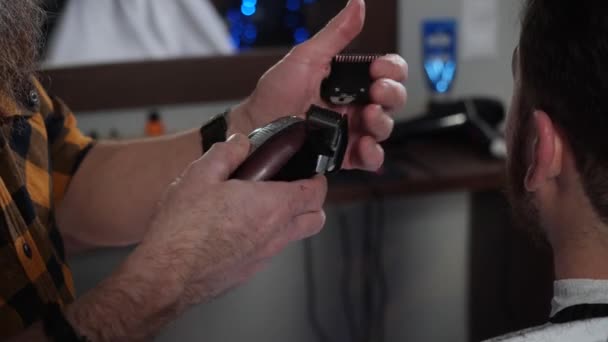 Close-up kapper in een geruit shirt maakt een kapsel typemachine voor het scheren — Stockvideo