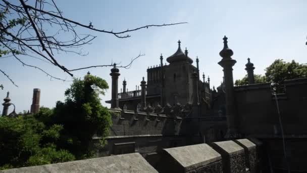 Ein geheimnisvolles altes graues Schloss, das an einem sonnigen Tag inmitten grüner Gärten steht — Stockvideo