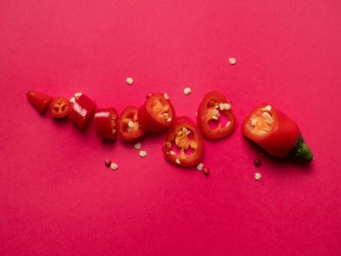 Parlak pembe arka planda çekirdekli doğranmış kırmızı biber. Yemek fotoğrafçılığı. 