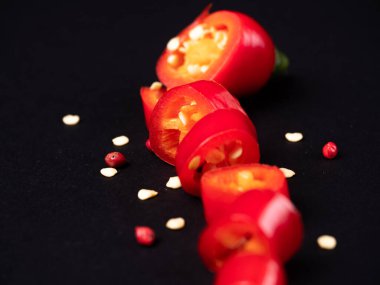 Siyah arka planda küçük taneciklerle parçalanmış taze kırmızı biber.