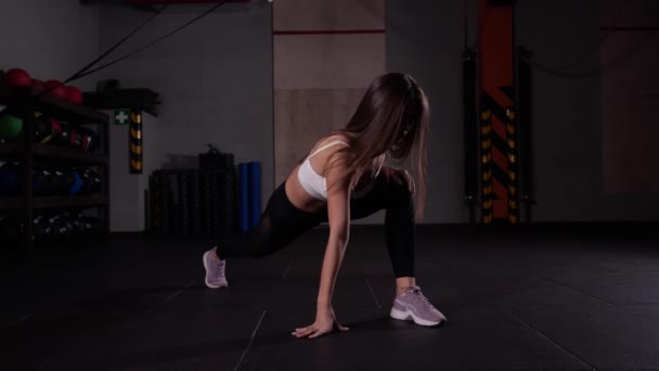 Schöne brünette Mädchen führt Übung für Bein Stretching Muskeln in der Turnhalle — Stockvideo