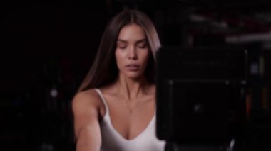 Kız simülatörde oturan ellerin kasları için egzersiz yapıyor.