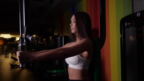 Menina morena realiza um exercício para os músculos flexão e flexionando os braços — Vídeo de Stock