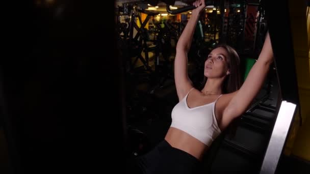 Dívka provádí cvičení pro svaly rukou ležící na simulátoru — Stock video