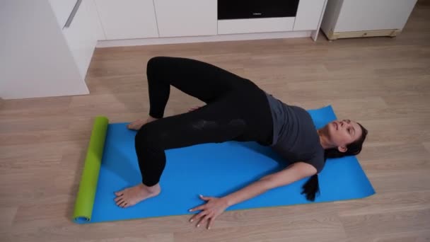Spor esmer kız mavi yoga minderinde vücut kaldırma egzersizi yapıyor. — Stok video