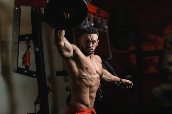  Güzel kaslı vücudu ve kasları olan erkek antrenör spor salonunda duruyor.
