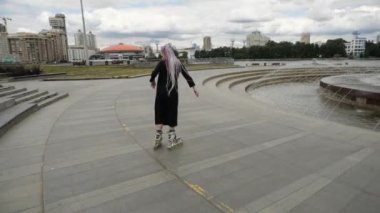 Şehirde paten kayan genç bir kızı vurmak.