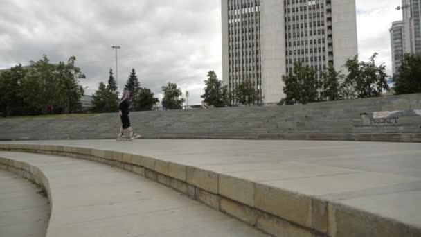 视频中，一个长相明亮的有趣女孩在城市里滑行 — 图库视频影像