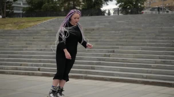 Video eines Mädchens in einem langen Kleid und mit hellem Haar, das durch die Stadt läuft — Stockvideo