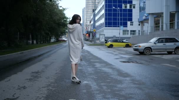 Video studentky v béžových šatech procházející se po městě po silnici — Stock video
