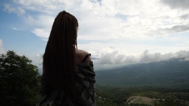 Sexy joven con los hombros abiertos y el pelo largo se levanta en la cima de la montaña — Vídeo de stock