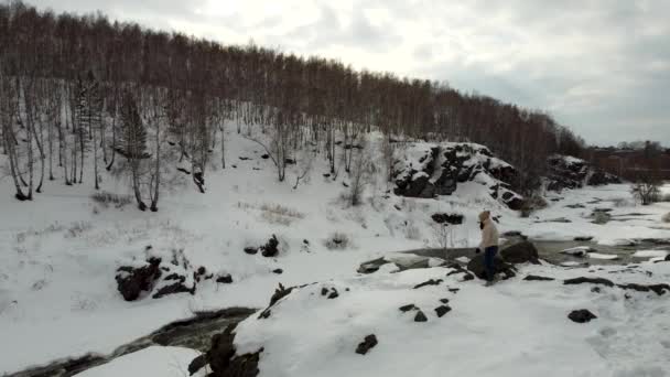 Wideo z wysokości dziewczyny turysta spaceruje po pokrytych śniegiem górach — Wideo stockowe