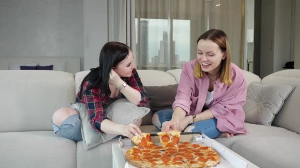 Mutlu genç arkadaşlar pizza yer ve rahat bir evde konuşurlar. — Stok video