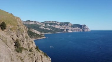 Dağ zirveleri, kayaları olan güzel deniz manzaralı bir dronun görüntüsü