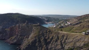 Bir deniz gemisinin, dağların ve körfezin kıyısındaki bir kasabanın videosu.