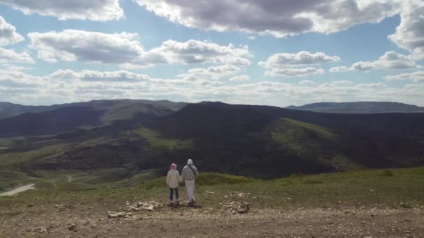 Para podróżników iść ręka w rękę w górach, ciesząc się pięknym krajobrazem — Wideo stockowe
