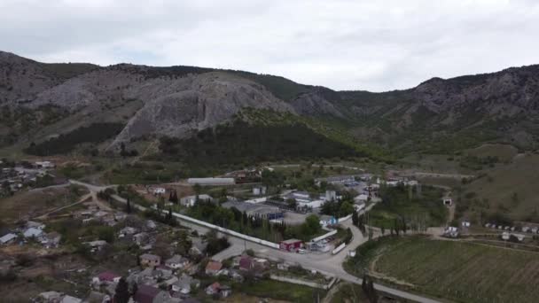 Pequeño pueblo verde en las montañas, disparando a vista de pájaro — Vídeo de stock