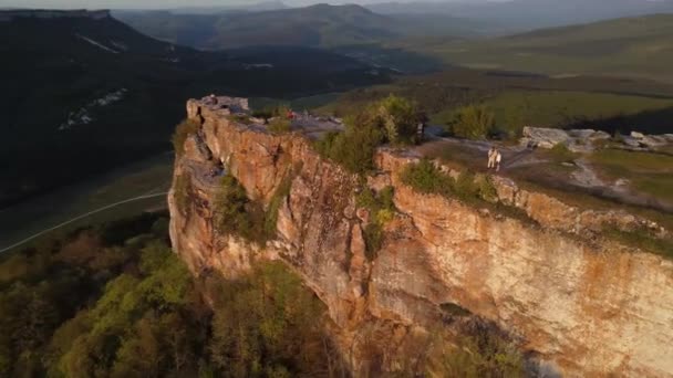 Touristes debout sur un canyon pittoresque avec des rochers à la lumière du coucher du soleil — Video