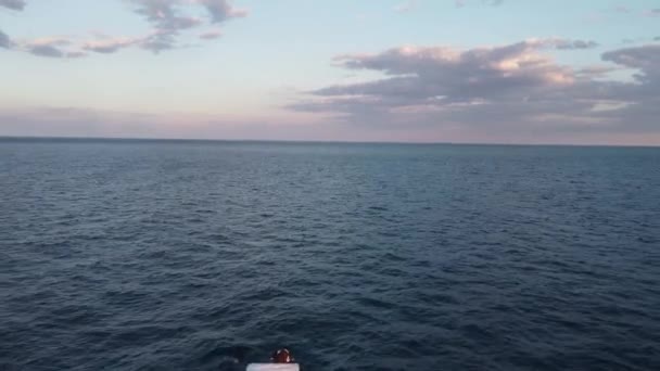 Schieten van boven een boot in de open zee die naar de horizon drijft — Stockvideo