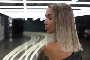 Vücudunda dövme olan muhteşem kız kameraya arkası dönük duruyor.