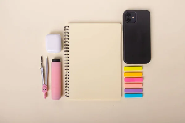 Vista superior de un escritorio con un teléfono inteligente, pegatinas de colores, accesorios. — Foto de Stock