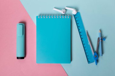 dizüstü bilgisayar, işaret, cetvel ve pusula mavi arkaplan üzerine dizilmiştir