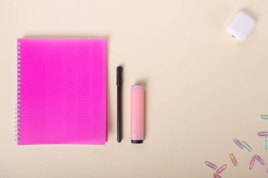 Bej bir arka planda okul not defteriyle minimalist düz uzanma düzeni