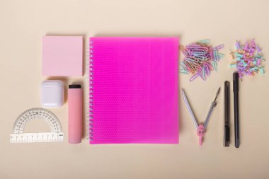 parlak pembe defter, renkli ataçlar, işaret ve kulaklıklar. 