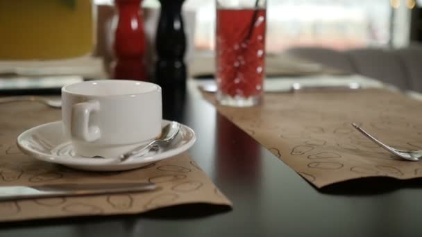 A womans hand pours tea from a glass kettle into a white mug — Stock Video