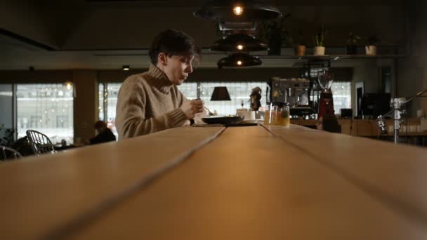 Vue de côté Une fille solitaire manger de la salade assis à une table de restaurant — Video