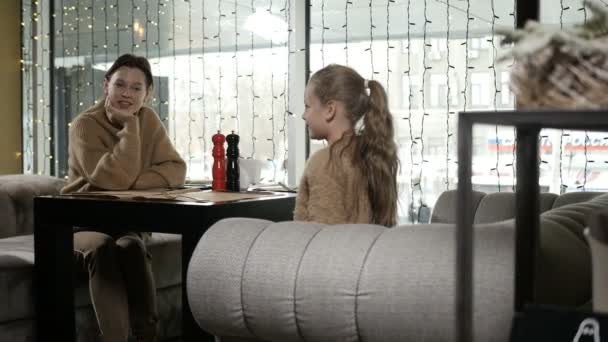 侍者端来食物给坐在咖啡店餐桌旁的一家人 — 图库视频影像