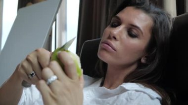 Güzel manikürlü bir kadın bir elmayı bıçakla keser. 