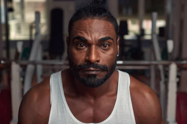 Spor salonunda duran çekici bir sporcunun portresi. 