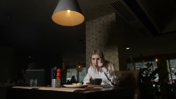 magányos szőke lány eszik levest ül egy étteremben 